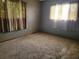 Cozy bedroom with plush carpeting, neutral walls, and natural light streaming through curtained windows for a relaxing atmosphere at 8344 Sw 107Th Pl, Ocala, FL 34481