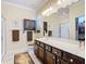 Well-lit bathroom featuring dark wood cabinets, a large mirror, and glass-enclosed shower at 9346 Sw 73Rd St, Ocala, FL 34481