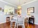 Dining area with hardwood floors, view of kitchen, stylish lighting, and neutral decor at 9346 Sw 73Rd St, Ocala, FL 34481