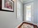 Bright foyer with a decorative front door, stylish rug, and shuttered window at 9346 Sw 73Rd St, Ocala, FL 34481