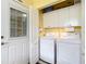 Well-equipped laundry room with a folding door, washer, dryer, and storage cabinets at 9346 Sw 73Rd St, Ocala, FL 34481