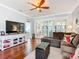 Comfortable living room with a brown sectional sofa, wooden floors, and natural light from large window shutters at 9346 Sw 73Rd St, Ocala, FL 34481