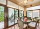 Bright sunroom features wicker furniture, a glass table, and sliding glass doors to the outdoor patio area at 9346 Sw 73Rd St, Ocala, FL 34481
