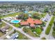 An aerial shot showcasing the clubhouse, pool, tennis courts, and parking area within a residential community at 9886 Se 178Th Ln, Summerfield, FL 34491