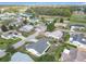 An aerial view of a neighborhood with single-Gathering homes, green lawns and a view of a nearby golf course and pond at 9886 Se 178Th Ln, Summerfield, FL 34491