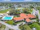 Aerial view of the clubhouse with a swimming pool, tennis courts, and a parking lot for community residents at 9886 Se 178Th Ln, Summerfield, FL 34491