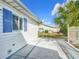Exterior view of the backyard features a concrete patio, white fencing, and lush landscaping at 9886 Se 178Th Ln, Summerfield, FL 34491