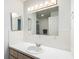 Bathroom vanity with white counter and backsplash, decorative tile, and large mirror at 9886 Se 178Th Ln, Summerfield, FL 34491