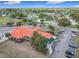 Aerial view of the community, showcasing the red-roofed clubhouse, parking area, and lush landscaping at 9886 Se 178Th Ln, Summerfield, FL 34491