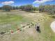 Aerial view of a driving range, with golfers practicing, and a golf cart nearby at 9886 Se 178Th Ln, Summerfield, FL 34491