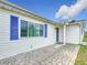 Side view of home showcasing blue shutters, lush lawn, and a paved walkway to the front door at 9886 Se 178Th Ln, Summerfield, FL 34491