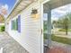 Home's exterior view featuring blue shutters, a stone walkway, and an inviting entryway light at 9886 Se 178Th Ln, Summerfield, FL 34491