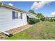 Exterior view of the home shows the side yard and landscaping with grass and stone at 9886 Se 178Th Ln, Summerfield, FL 34491