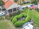 A close-up aerial view of the clubhouse entrance and surrounding landscaping, including an American flag at 9886 Se 178Th Ln, Summerfield, FL 34491