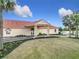An eye-level view of The Links Club clubhouse entrance, with a well-manicured lawn in front at 9886 Se 178Th Ln, Summerfield, FL 34491