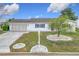 Charming single-story home with white exterior, landscaped front yard, and attached two-car garage at 9886 Se 178Th Ln, Summerfield, FL 34491