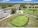 Aerial view of the golf course, showcasing lush greens, a red roof clubhouse, and meticulously designed fairways at 9886 Se 178Th Ln, Summerfield, FL 34491