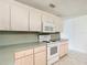 Bright kitchen featuring white appliances, tile floors, and light wood cabinets at 9886 Se 178Th Ln, Summerfield, FL 34491