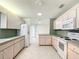 Bright kitchen featuring white appliances, tile floors, and light wood cabinets at 9886 Se 178Th Ln, Summerfield, FL 34491