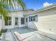 Spacious outdoor patio area with doors to the home and a privacy wall with nice landscaping at 9886 Se 178Th Ln, Summerfield, FL 34491