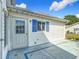 Exterior shot of the patio and shows the home's siding, blue shutters, door and sunny weather at 9886 Se 178Th Ln, Summerfield, FL 34491