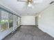 Bright sunroom features carpeted floors, ceiling fan, and large windows bringing in lots of natural light at 9886 Se 178Th Ln, Summerfield, FL 34491