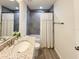 Bright bathroom featuring a granite countertop vanity, gray-tiled shower, and updated fixtures at 1370 Sw Obee Ridge Rd, Dunnellon, FL 34432