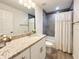 Bright bathroom featuring a granite countertop vanity, gray-tiled shower, and updated fixtures at 1370 Sw Obee Ridge Rd, Dunnellon, FL 34432