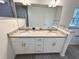 Bathroom featuring double sinks, granite countertops, white cabinets, and a large mirror at 1370 Sw Obee Ridge Rd, Dunnellon, FL 34432