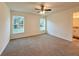 Light-filled bedroom with neutral carpet, ceiling fan, and windows overlooking the landscaped yard at 1370 Sw Obee Ridge Rd, Dunnellon, FL 34432