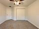 Comfortable bedroom with carpet, ceiling fan, closet, and a door at 1370 Sw Obee Ridge Rd, Dunnellon, FL 34432