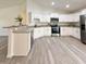 Bright kitchen with stainless steel appliances, granite countertops and gray wood-look flooring plus bar countertop at 1370 Sw Obee Ridge Rd, Dunnellon, FL 34432