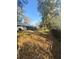 Large, partially shaded backyard with lush trees and an expansive lawn and a view of the side of the home at 13949 Se 53Rd Ave, Summerfield, FL 34491