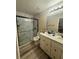 Modern bathroom featuring marble-tiled shower and double sink vanity with granite countertop at 13949 Se 53Rd Ave, Summerfield, FL 34491