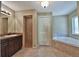 Bathroom featuring dual sinks, a soaking tub, a walk in shower, and a window at 1645 Sw 168Th Loop, Ocala, FL 34473