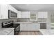 Bright, white kitchen features stainless steel appliances, an island, and modern finishes for cooking at 17672 Sw 112Th Ln, Dunnellon, FL 34432