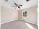 This bedroom has carpet flooring, a ceiling fan and a view to the outside at 17718 Sw 112Th Ln, Dunnellon, FL 34432