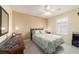 Comfortable bedroom featuring a ceiling fan, and a window with bright white shutters at 17959 Se 89Th Natchez Ave, The Villages, FL 32162