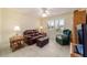 Comfortable living room with cozy seating, window, ceiling fan, and tiled floor at 17959 Se 89Th Natchez Ave, The Villages, FL 32162