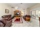 Spacious living room with plush sofas, a ceiling fan, tiled floors, and a large entertainment center at 17959 Se 89Th Natchez Ave, The Villages, FL 32162