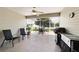 Screened-in patio with outdoor seating, ceiling fan, and a grill at 17959 Se 89Th Natchez Ave, The Villages, FL 32162
