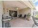 Enclosed patio features a ceiling fan, seating, and a grill for outdoor enjoyment at 17959 Se 89Th Natchez Ave, The Villages, FL 32162