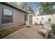 Quaint backyard with two chairs and potted plants against a decorative privacy wall and brown siding at 1902 Se 37Th Court Cir, Ocala, FL 34471