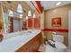 Updated full bathroom featuring marble countertop, updated lighting, wood cabinetry, and red accents at 1902 Se 37Th Court Cir, Ocala, FL 34471