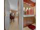 View into the half bathroom with updated lighting, red accents, vanity with marble countertop and wood cabinets at 1902 Se 37Th Court Cir, Ocala, FL 34471