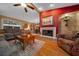 Elegant living room with a fireplace, hardwood flooring, and a view into the dining area, ideal for gatherings at 1902 Se 37Th Court Cir, Ocala, FL 34471