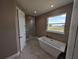 Bright bathroom showcasing a modern standalone tub, tiled floors, and stylish fixtures at 1972 Nw 85 Loop, Ocala, FL 34475