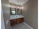 Bathroom features double sink vanity, granite counters, stylish lights, wood cabinetry, and tile floor at 1972 Nw 85 Loop, Ocala, FL 34475