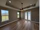 Bright bedroom with tray ceiling, ceiling fan, hardwood floors, and ample natural light at 1972 Nw 85 Loop, Ocala, FL 34475