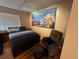 Relaxing bedroom showcasing a queen bed, accent chair, and colorful ocean themed artwork on the wall at 20800 River Dr # A17, Dunnellon, FL 34431